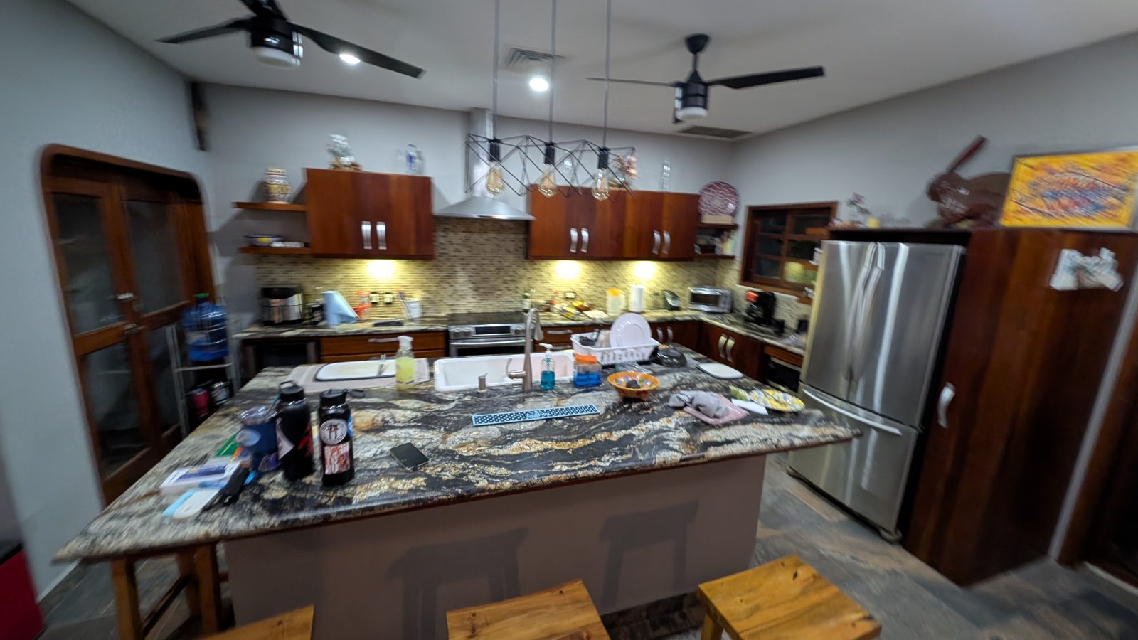 The kitchen, with a marble island, dark hardwood cabinetry and stainless appliances